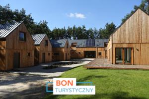 a group of wooden houses in a yard at Osada Osjaków in Osjaków