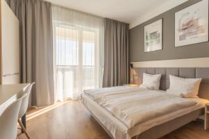 a bedroom with a large bed and a large window at RentPlanet - Apartamenty Wolska in Warsaw