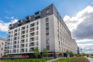 a white building with balconies on the side of it at RentPlanet - Apartamenty Wolska in Warsaw