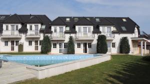 a large house with a swimming pool in front of it at EUROPA APARTAMENTY in Trzęsacz
