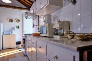 a kitchen with a counter top with a microwave at Casa D'Alfaias in Nordeste