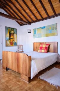 1 dormitorio con 1 cama con cabecero de madera en Casa D'Alfaias, en Nordeste