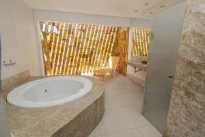 a bathroom with a bath tub in a room at Raru's Motel Litoral Norte (Adult Only) in Natal