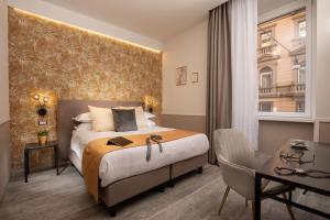 una camera d'albergo con un letto grande e una scrivania di Sophie Terrace Hotel a Roma