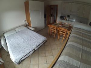 ein Schlafzimmer mit 2 Betten und eine Küche mit einem Tisch in der Unterkunft Monolocale Casericc in Piatta