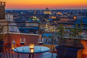 2 bicchieri da vino su un balcone con vista sulla città di Sophie Terrace Hotel a Roma