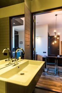 Hotel Mosaic Appartments في أمستردام: حمام مع حوض ومرآة
