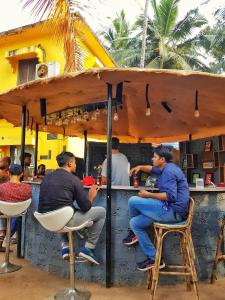 Eine Gruppe von Männern, die an einer Bar sitzen. in der Unterkunft The Lost Hostel, Goa - Palolem Beach in Palolem