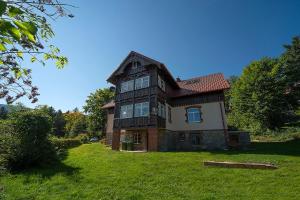 une grande maison sur un champ herbeux planté d'arbres dans l'établissement Apartamenty Sun Seasons 24 - Willa Karpacz, à Karpacz