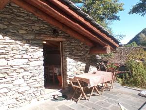 una mesa y sillas sentadas fuera de un edificio de piedra en La Petite Maison, en Arvier