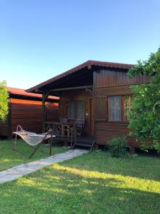 una casa de madera con una hamaca frente a ella en Ozge Bungalow Hotel en Cıralı