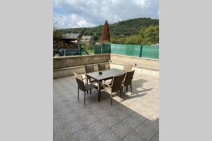 a patio with a table and chairs on a patio at GITE , AU DORMEUR DU VAL in Vireux-Wallerand