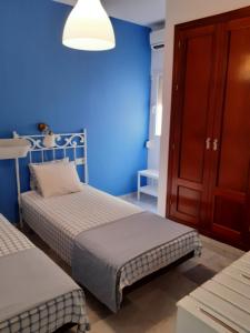 sypialnia z 2 łóżkami i niebieską ścianą w obiekcie Centro Histórico con Balcón 2 Bedrooms w Maladze