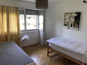 Schlafzimmer mit einem Bett und einem Fenster in der Unterkunft Bijou Appartment in Zollikofen