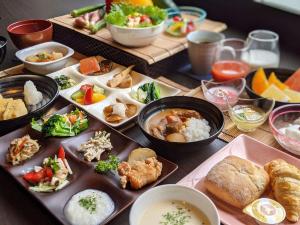 una mesa cubierta con diferentes tipos de comida en platos en Kutsurogijyuku Shintaki en Aizuwakamatsu