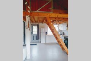 uma cozinha com uma escada que conduz a um loft em Chalet en forêt, brame du cerf em Valpuiseaux