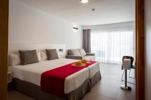 a bedroom with a large bed with a red blanket at Hotel Taimar in Costa Calma