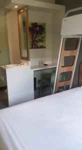 Habitación con cama, escritorio y espejo. en SUN1 BENONI en Benoni