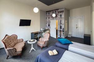 - une chambre avec un lit, deux chaises et une télévision dans l'établissement Good Time Residence, à Łódź