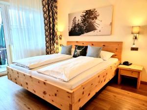 uma grande cama de madeira num quarto com em Seehotel Hartung & Ferienappartements em Füssen