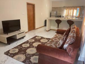a living room with a couch and a flat screen tv at Gala Beach Self-Catering in Glacis