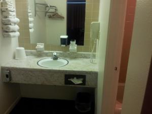 y baño con lavabo y espejo. en Indian Head Motel, en Winamac