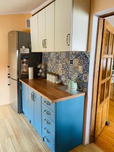 uma cozinha com armários azuis e um frigorífico em cosy & comfy - OLD TOWN em Poznań