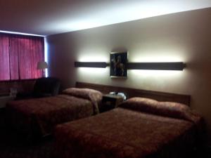 ein Hotelzimmer mit 2 Betten und einem Sofa in der Unterkunft Indian Head Motel in Winamac