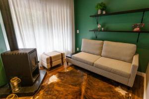 a living room with a couch and a tv at Umani Pousada in Bento Gonçalves