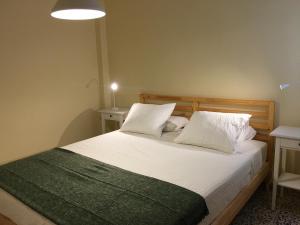 una camera da letto con letto, lenzuola e cuscini bianchi di Apartamento Los Laureles - El Fraile ad Arona