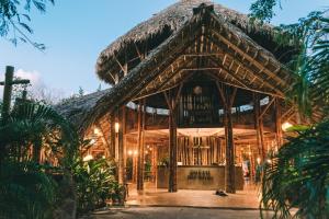 Dreamsea Surf Resort Nicaragua في سان خوان ديل سور: مبنى من الخيزران مع سقف من القش