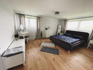 a living room with a black couch and a desk at Apartamenty Pod Kątami in Kamienica