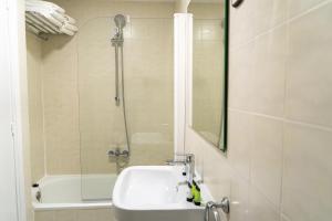 uma casa de banho com um chuveiro, um lavatório e uma banheira em Hotel Aubí em Sant Antoni de Calonge