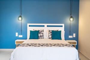 Dormitorio azul con cama blanca y paredes azules en Hotel Aubí, en Sant Antoni de Calonge