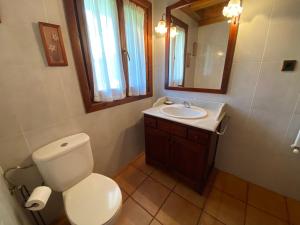 een badkamer met een toilet, een wastafel en een spiegel bij Casa Sansón in Chía
