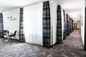 una fila de cortinas en una habitación con una mesa en Dom-Hotel, en Worms