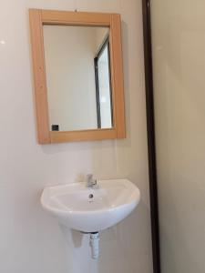 a white sink in a bathroom with a mirror at Karta House in Ubud