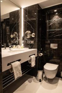 La salle de bains noire est pourvue de toilettes et d'un lavabo. dans l'établissement Casino 2000 - Adult Guests Only, à Mondorf-les-Bains