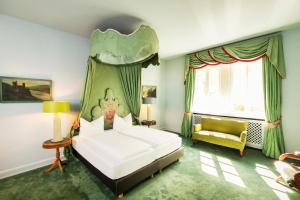 ein Schlafzimmer mit einem Bett, einem Stuhl und einem Fenster in der Unterkunft Hotel Waldesruh Am See in Aumühle