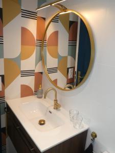 a bathroom with a sink and a mirror at Studio Cosy proche Grand-Champ Home Sweet Home in Plumergat