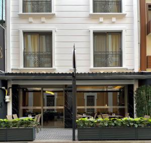 a building with tables and chairs in front of it at Mithras Hotel in Izmir