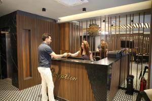 een man aan een balie in een lobby bij Mithras Hotel in Izmir