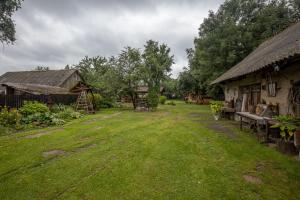 un patio con dos edificios antiguos y un campo de césped en Agrousadba UTSISHY - U hutarskoj tsishy, Volkovysk, en Vawkavysk