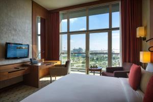 a hotel room with a bed and a large window at Yas Island Rotana Abu Dhabi in Abu Dhabi
