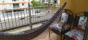 een hangmat op een balkon met uitzicht op een straat bij Aconchegante e Amplo Apartamento Familiar pertinho da Praia! in Guarujá