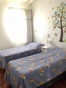 2 letti in una camera da letto con un murale sull'albero di Dpto. Tribuno a Salta