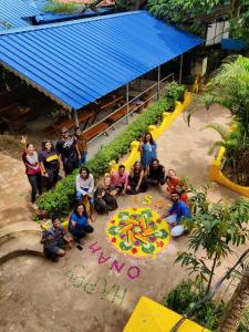 a group of people posing for a picture in a garden at The Lost Hostel, Varkala - Helipad in Varkala