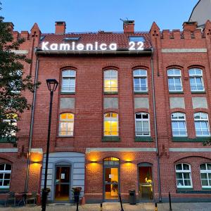 a red brick building with a sign on it at Kamienica 22 Old Town in Gdańsk