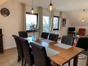 uma sala de jantar com uma mesa de madeira e cadeiras em Ferienwohnung Lix direkt am Waldrand em Frankenau