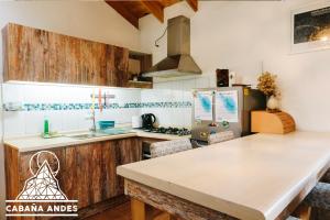 eine Küche mit Holzschränken und einer Arbeitsplatte in der Unterkunft Cabaña Andes in El Canelo